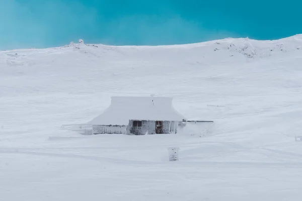 Winter cabin caught in snow on Velika Planina