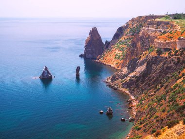 Güneşli bir günde kayalarla güzel bir deniz manzarası.