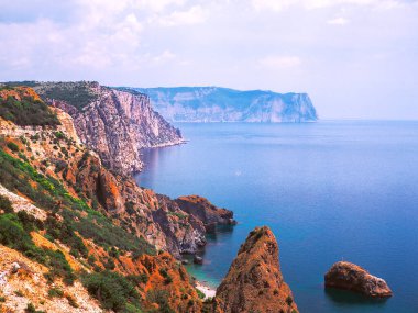 Güneşli bir günde kayalarla güzel bir deniz manzarası.