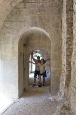 Antik taş duvarda yürüyen iki turist.