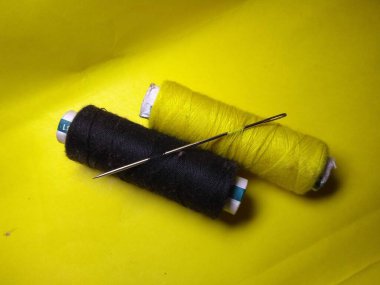 Yeşil kumaşa iplikler dikiyorum.