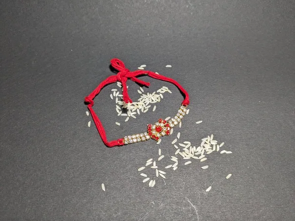 Raksha Bandhan, Kara Arkaplanda Rakhi ile Hint festivali. Geleneksel Hint bilekliği kız kardeşler ve erkek kardeşler arasındaki aşkın sembolüdür..