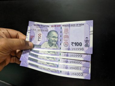 Elinde Hint rupisi banknotları var. Hint Rupisi Hindistan 'ın ulusal para birimidir.