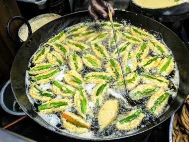 Kızarmış yeşil biber ve kızartma tavası. Hint Çay Saati Atıştırmalıkları veya Menasinakaayi, Geleneksel Doğu Yemekleri.