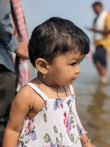 Bebek Kız nehir suyunda farklı bir ifadeyle oynuyor.