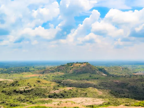 Mavi gökyüzü ve bulutlar üzerinde yeşil dağ manzarası 