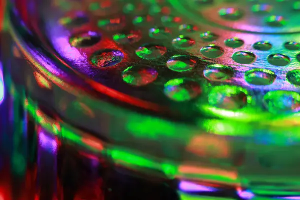 Camda delikler olan yeşil ve mavi ışıkların soyut arkaplanı