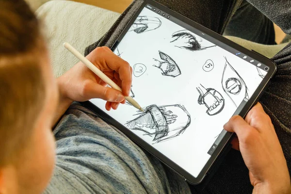 Artist creating digital drawing on tablet using digital pen Close up male's hand holding digital pen. High quality photo