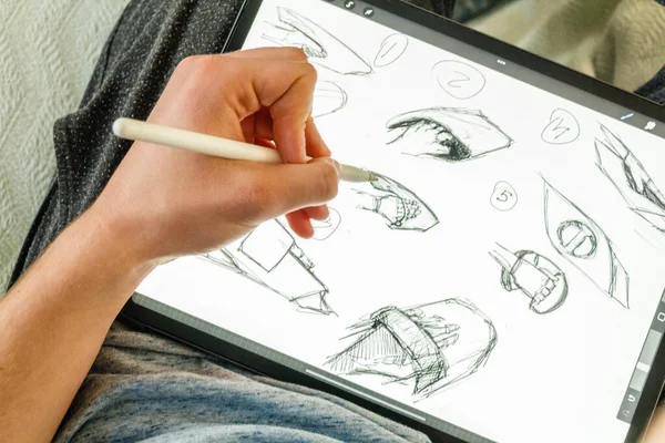 Artist creating digital drawing on tablet using digital pen Close up males hand holding digital pen. High quality photo