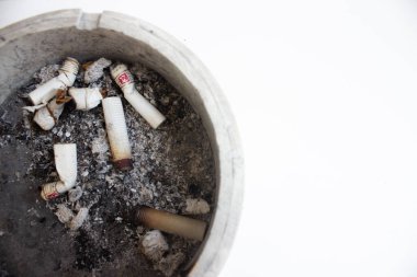dirty ashtray full of cigarette butts isolated in white background