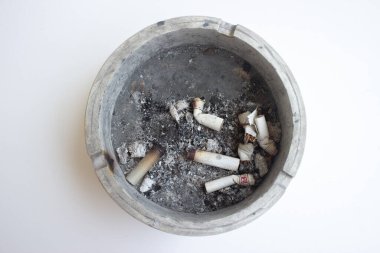 dirty ashtray full of cigarette butts isolated in white background
