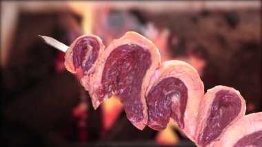 Geleneksel Brezilya picanha şiş üzerinde ızgara ve arka planda pürüzsüz hareket videosunda ateş