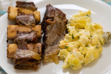 Geleneksel ızgara pirzola ve mayonez salatası. Gaucho kültürü