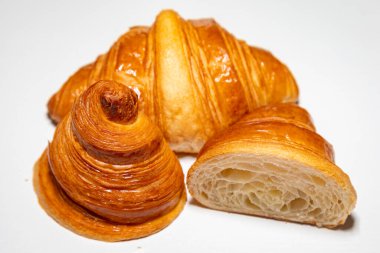 Sade arka planda gölgesi olan altın rengi tereyağlı kruvasan..