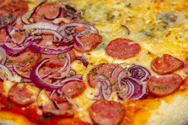 Tipik Brezilya pizzası yarım sucuklu ve dört peynirli.