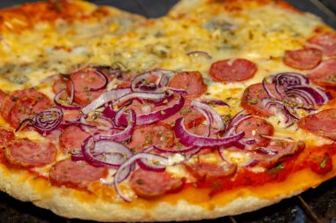 Tipik Brezilya pizzası yarım sucuklu ve dört peynirli.