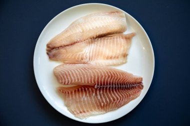 Tilapia filetosu ya da Aziz Peter balık Oreochromis niloticus. Beyaz arkaplanda izole