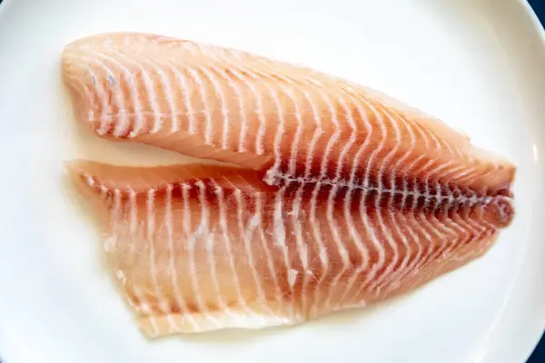 stock image Fillet of tilapia or Saint Peter fish Oreochromis niloticus. Isolated on white background