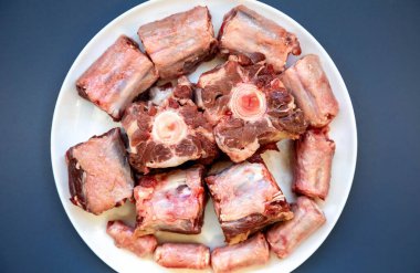 Yuvarlak beyaz tabakta çiğ sığır kuyruğu..