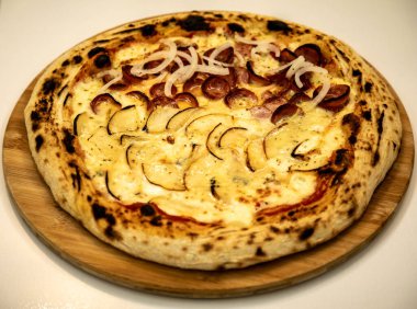 Gorgonzola ve peynirli yarım armut ve soğanlı yarım biberli pizza.