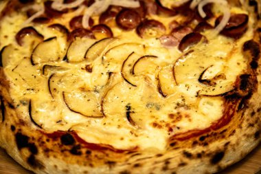 Gorgonzola ve peynirli yarım armut ve soğanlı yarım biberli pizza.