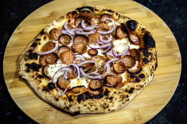 Stock image Rustic artisanal pepperoni pizza with red onion