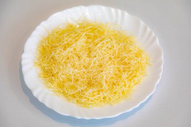 Beyaz tabakta rendelenmiş parmesan peyniri. Pecorino Romano peyniri