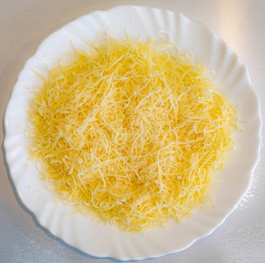 Beyaz tabakta rendelenmiş parmesan peyniri. Pecorino Romano peyniri