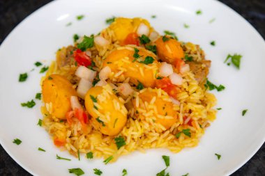 Geleneksel Brezilya yemeği pilavı, tavuk ve pequi (caryocar brasileinse) Galinhada goiana olarak bilinir.