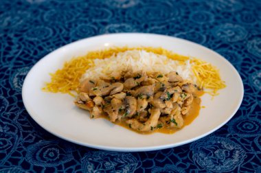 Geleneksel mantarlı tavuk stroganoff, saman patatesi ve beyaz pirinç.