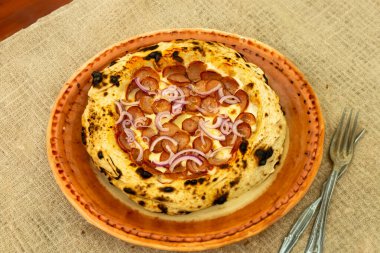 Geleneksel rustik zanaatkar pepperoni ve soğanlı pizza. Calabresa sosisli pizza.