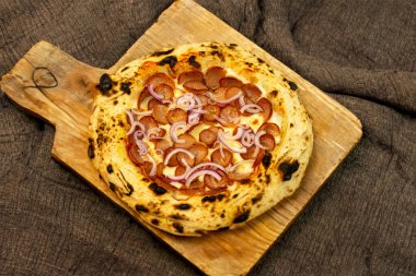 Geleneksel rustik zanaatkar pepperoni ve soğanlı pizza. Calabresa sosisli pizza.