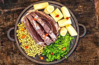 Traditional rustic tropical Brazilian dish, sun-dried beef with green beans, cassava, biquinho pepper. Creative rustic photography clipart