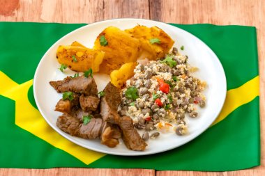 Traditional rustic tropical Brazilian dish, sun-dried beef with green beans, cassava, biquinho pepper. Creative rustic photography clipart