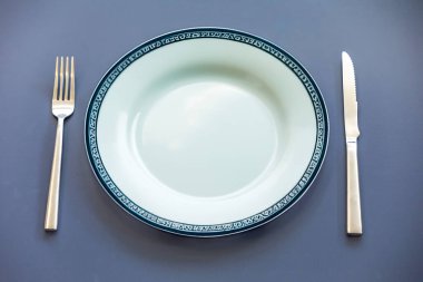 Üstünde metal çatal bıçak olan boş bir tabaka görünümü