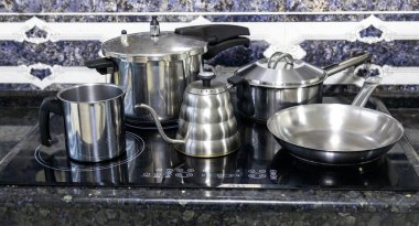 Çeşitli paslanmaz çelik kaplar, tavalar ve mutfak aletleri.