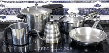 Çeşitli paslanmaz çelik kaplar, tavalar ve mutfak aletleri.