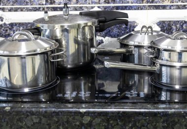 Çeşitli paslanmaz çelik kaplar, tavalar ve mutfak aletleri.