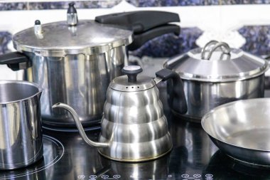 Çeşitli paslanmaz çelik kaplar, tavalar ve mutfak aletleri.