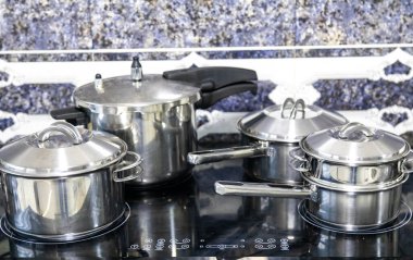 Çeşitli paslanmaz çelik kaplar, tavalar ve mutfak aletleri.