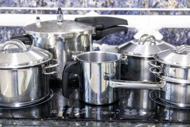 Çeşitli paslanmaz çelik kaplar, tavalar ve mutfak aletleri.