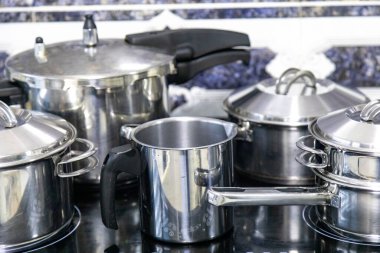 Çeşitli paslanmaz çelik kaplar, tavalar ve mutfak aletleri.
