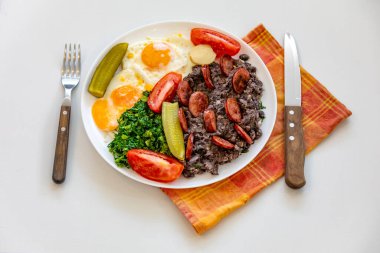 Kaba, besleyici Brezilya yemekleri, yumurtalı siyah fasulye güveci, ızgara sosis, turşu ve doğal fermantasyon, lahana ve sebze. Gerçek yemek.