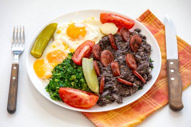 Kaba, besleyici Brezilya yemekleri, yumurtalı siyah fasulye güveci, ızgara sosis, turşu ve doğal fermantasyon, lahana ve sebze. Gerçek yemek.