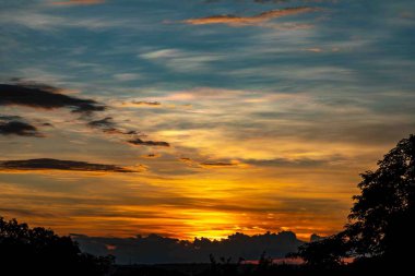 Yoğun turuncu ışıklar ve huzurlu dramatik manzaralı gün doğumu