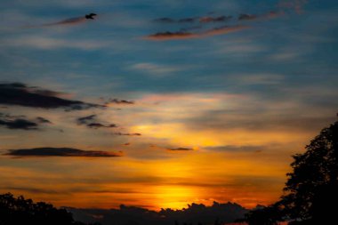 Yoğun turuncu ışıklar ve huzurlu dramatik manzaralı gün doğumu