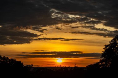 Yoğun turuncu ışıklar ve huzurlu dramatik manzaralı dramatik bir gün doğumu.