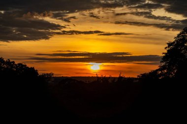 Yoğun turuncu ışıklar ve huzurlu dramatik manzaralı dramatik bir gün doğumu.