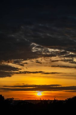 Yoğun turuncu ışıklar ve huzurlu dramatik manzaralı dramatik bir gün doğumu.