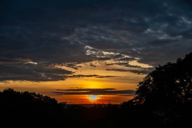 Yoğun turuncu ışıklar ve huzurlu dramatik manzaralı dramatik bir gün doğumu.